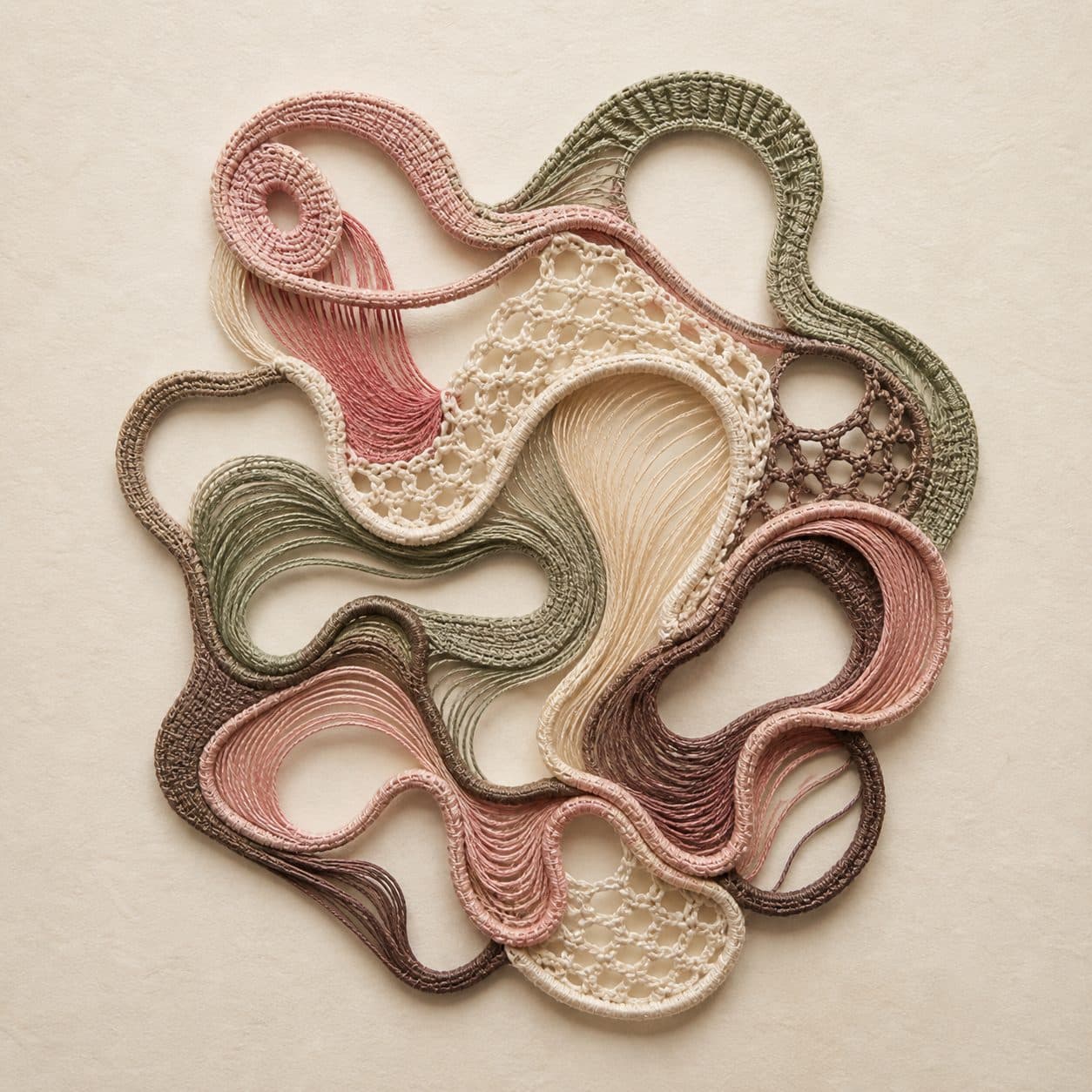 Abstract crochet wall art in dusty rose, sage and cream